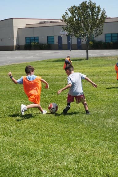 Two students going for the same soccer ball