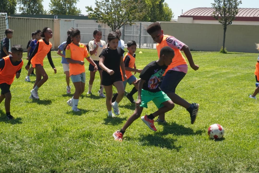 Kids playing intramural soccer on a school field