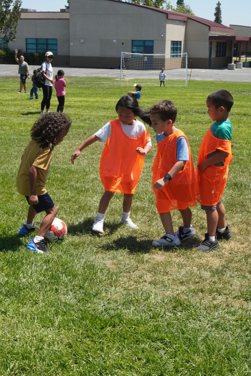 Younger students playing soccer at school